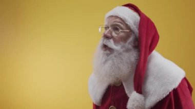 Stüdyoda poz veren ve el kol hareketi yapan Noel Baba portresi