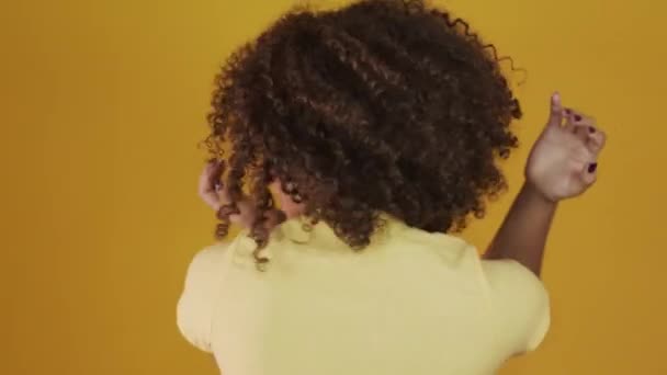 Joven Brasileña Rizada Haciendo Gestos Posando Sobre Fondo Amarillo — Vídeos de Stock