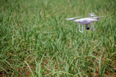 Yeşil alanın üzerinde uçan beyaz dron