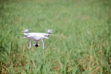 Yeşil alanın üzerinde uçan beyaz dron