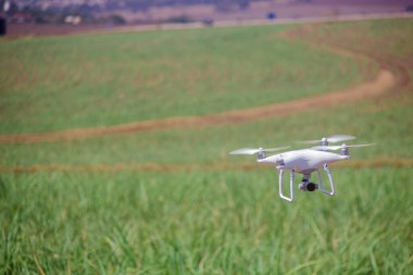 Yeşil alanın üzerinde uçan beyaz dron