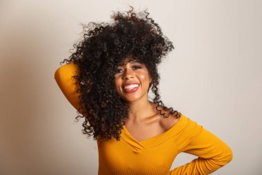 Kıvırcık saçlı, kameraya bakıp gülümseyen genç Afro-Amerikalı kadın. Kıvırcık saçlı, kameraya bakıp gülümseyen tatlı afro kız..