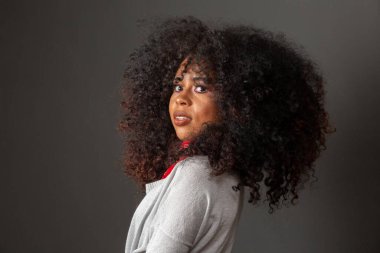 Afro saç stili ve cazibeli makyajlı Afro-Amerikan kadının güzel portresi. Brezilyalı kadın. Karışık ırk. Kıvırcık saçlı. Saç stili. Siyah arkaplan.