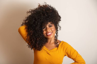 Kıvırcık saçlı, kameraya bakıp gülümseyen genç Afro-Amerikalı kadın. Kıvırcık saçlı, kameraya bakıp gülümseyen tatlı afro kız..