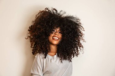 Afro saç stili ve cazibeli makyajlı Afro-Amerikan kadının güzel portresi. Brezilyalı kadın. Karışık ırk. Kıvırcık saçlı. Saç stili. Beyaz arkaplan.