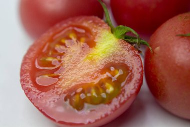 Beyaz masa arkasında olgun kırmızı domatesler.