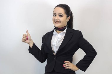 Beyaz arka planda yalnız poz veren şık kostümlü sevimli hostes.