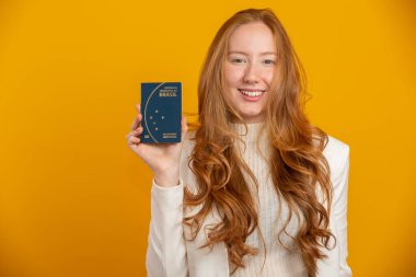 Yolculuktaki güzel kızıl saçlı, kıvırcık saçlı kız. Bir dahaki sefere. Brezilya pasaportlu bir kız. Sarı üzerine.