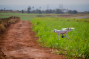 Yeşil alanın üzerinde uçan beyaz dron