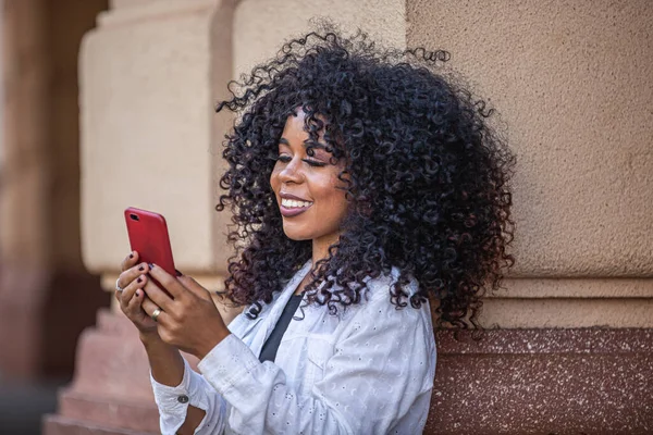 Joven Cabello Rizado Mujer Negra Caminando Usando Teléfono Celular Mensajes —  Fotos de Stock