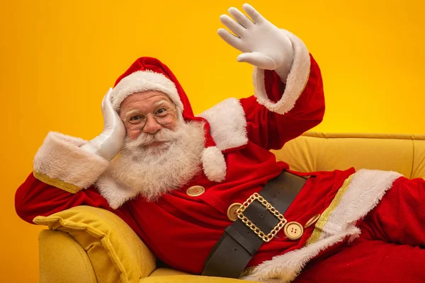 Noel Baba Sarı Arka Planda Sarı Koltukta Oturuyor Fotokopi Alanı — Stok fotoğraf