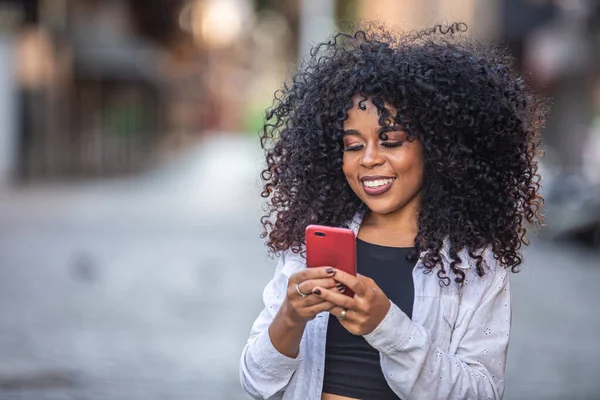 Jovem Cabelo Encaracolado Mulher Negra Andando Usando Telefone Celular Enviar — Fotografia de Stock