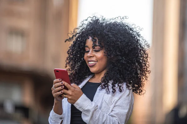 Joven Cabello Rizado Mujer Negra Caminando Usando Teléfono Celular Mensajes — Foto de Stock