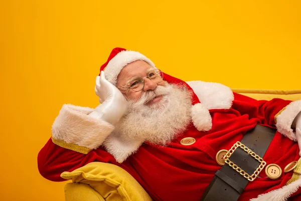 Noel Baba Sarı Arka Planda Sarı Koltukta Oturuyor Fotokopi Alanı — Stok fotoğraf