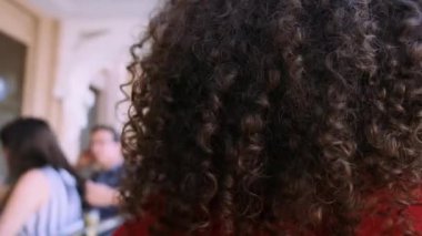 Şehrin arka planında poz veren şık kıvırcık kadın