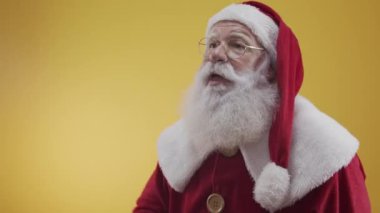 Stüdyoda poz veren ve el kol hareketi yapan Noel Baba portresi