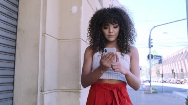 Elegante Mujer Rizada Usando Teléfono Inteligente Posando Fondo Ciudad — Vídeo de stock