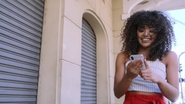 Elegante Mujer Rizada Usando Teléfono Inteligente Posando Fondo Ciudad — Vídeo de stock