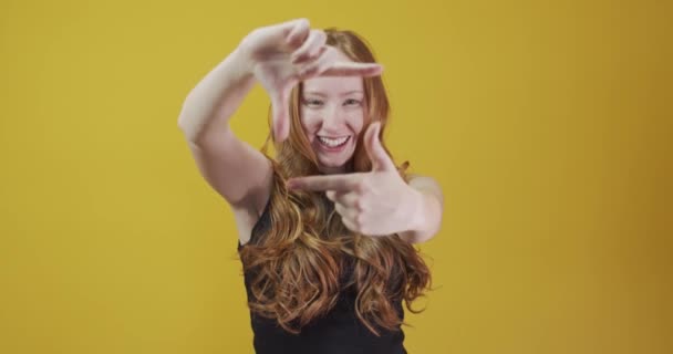 Rödhårig Ung Kvinna Poserar Gest Gul Bakgrund — Stockvideo