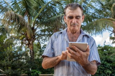 Avuç içi arka planında dijital tablet kullanan olgun bir adam