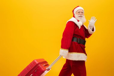 Noel Baba ve bavulu. Yılbaşı seyahati konsepti. Noel Baba havaalanında..