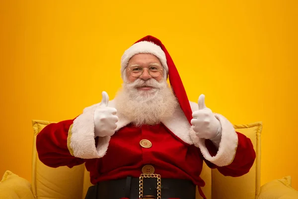 Papai Noel Sentado Sofá Amarelo Fundo Amarelo Com Espaço Cópia — Fotografia de Stock