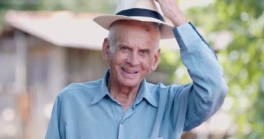 Bahçede poz veren yaşlı adamın portresi.