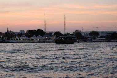Bangkok, Tayland, 25 Aralık 2018. Bazı gemiler akşam geç saatlerde Chao Phraya Nehri 'nde yelken açarlar. Nehir kıyısı.