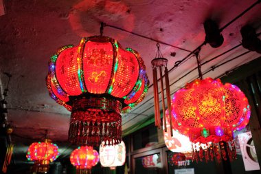 Karanlık bir gecede birkaç kırmızı ışık şehrin caddesini aydınlatıyor..