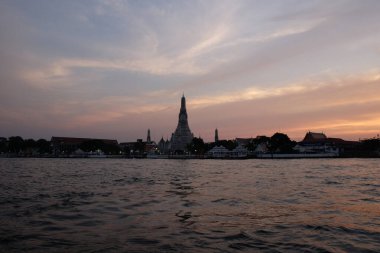 Budist tapınağı Wat Arun 'un üzerinde gün batımı. Chao Phraya Nehri 'nin su yüzeyi.