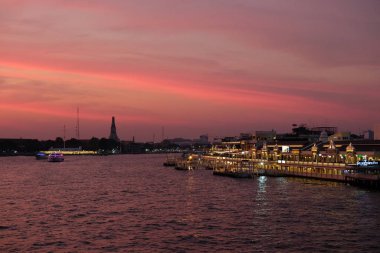 Bangkok, Tayland, 26 Aralık 2018. Gün batımında Chao Phraya nehrinin kıyısında restoranların aydınlanması. Pembe bulutlar akşam şehrini kaplıyor.