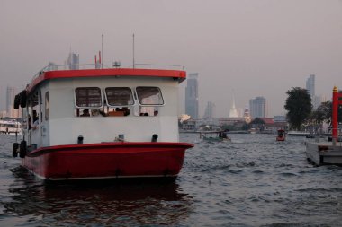 Bangkok, Tayland, 26 Aralık 2018. Nehir tramvayı insanları Chao Phraya Nehri 'nden geçirir. Modern binaların manzarası.