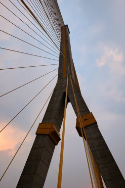 Gökyüzüne karşı kocaman bir asma köprünün pilon ve metal kabloları..