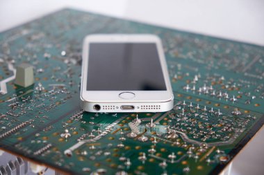 Chernihiv bölgesi, Ukrayna, 25 Nisan 2019. Akıllı telefon bir bilgisayar devre kartında yatıyor..