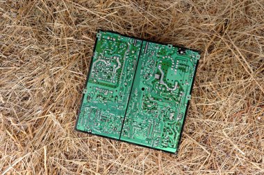 Chernihiv bölgesi, Ukrayna, 7 Mayıs 2019. Eski bir bilgisayar devre kartı saman yığınının üzerinde yatıyor..