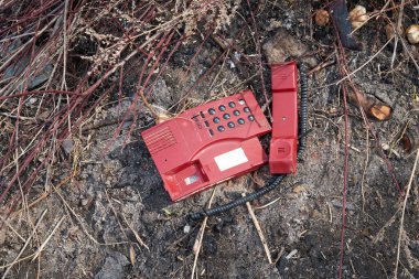 Chernihiv bölgesi, Ukrayna, 25 Nisan 2019. Arazi dolgusunda eski bir telefon var..