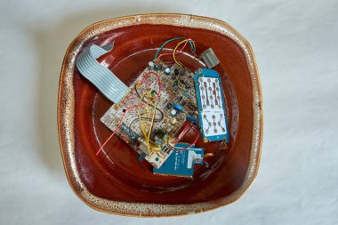 Chernihiv bölgesi, Ukrayna, 26 Nisan 2019. Eski oksitlenmiş mikro devreler ve baskılı devre kartları bir tabağın üzerinde..