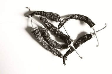 Kırmızı kalp, beyaz arka planda kırmızı biberden oluşmuş. Aşkın sembolü. Siyah ve beyaz resim.