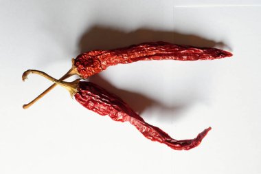 Beyaz arka planda iki kırmızı biber fotoğrafı..