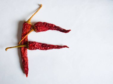 Beyaz arka planda kırmızı biberle kaplanmış F harfi. F harfi şeklinde bir sembol. F harfi beyaz arkaplanda..