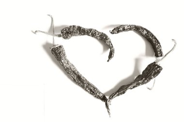 Kırmızı kalp, beyaz arka planda kırmızı biberden oluşmuş. Aşkın sembolü. Siyah ve beyaz resim.