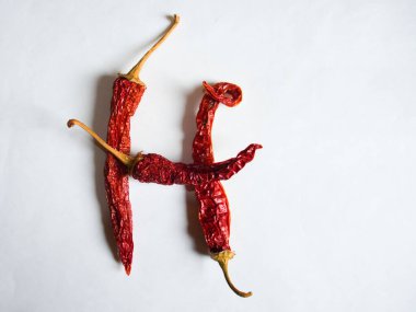 H harfi beyaz arka planda kırmızı biberle kaplanmış. H harfinde beyaz arka planda H harfinde H. Pepper harfi şeklinde bir sembol..