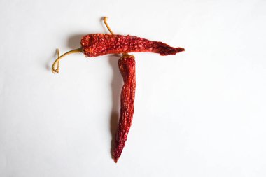 Beyaz arka planda kırmızı biberli T harfi. T harfinde T harfi şeklinde bir sembol. T harfinde beyaz bir arkaplan..