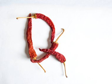 Q harfi beyaz arka planda kırmızı biberlerle kaplanmış. Q harfinde beyaz bir arkaplanda Q harfinde Q harfinde sıralanmış Q harfi şeklinde bir sembol..