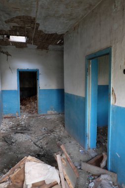 Mobilya parçaları eski terk edilmiş bir binanın koridorunda yerde yatıyor..