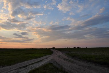 Akşamları tarlada iki köy yolunun çatalı. Akşam manzarası.