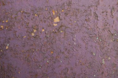 Arka plan olarak mor pürüzlü yüzey. Duvardan boya soymak. Doku.