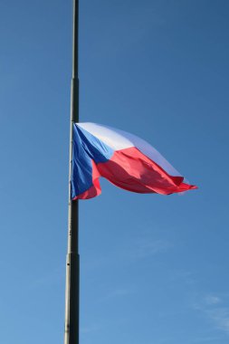 Alçaltılmış bir Çek bayrağı rüzgarda dalgalanıyor.