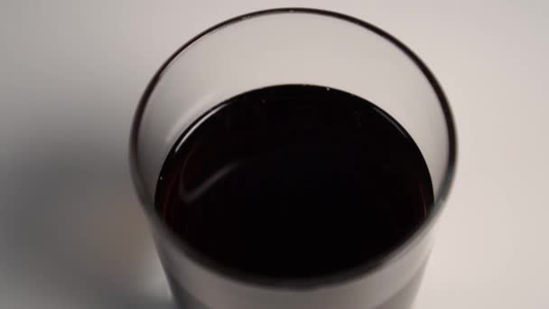 Cola Dinglar Ett Glas Ett Vitt Bord Slow Motion Närbild — Stockvideo