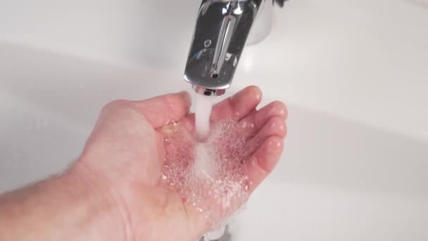 Wasser Aus Einem Brillanten Badezimmerhahn Wird Auf Die Hand Eines — Stockvideo